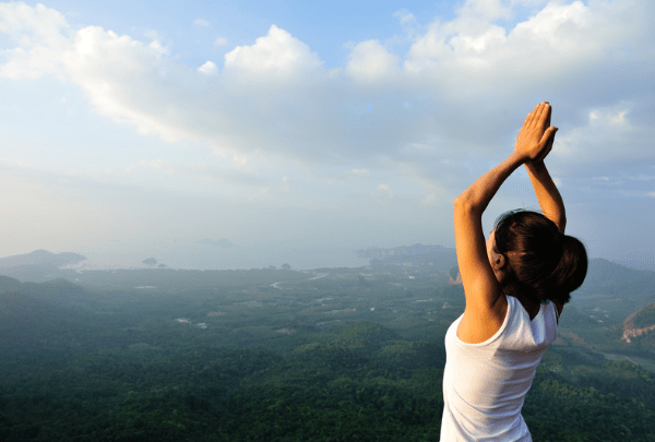 a successful yoga teacher at the top of a mountain