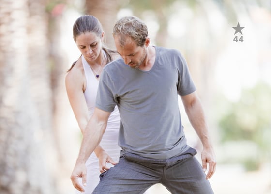 yoga teacher guiding a student through asana