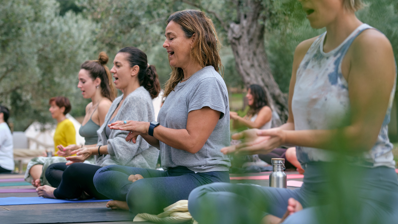 women taking part in a yoga training course, they are chanting